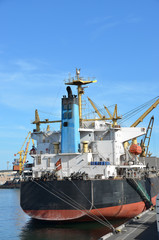 Naklejka premium Bulk cargo ship under port crane bridge, Odessa, Ukraine