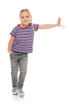 Little Girl Leaning Against A White Wall.