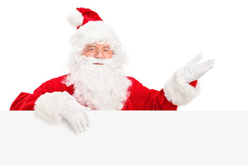 Santa Claus posing behind a billboard and gesturing