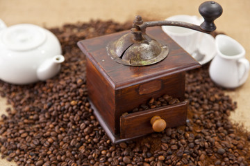 Macinino e teiera su chicci di caffè