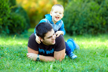 happy father and son playing on green field