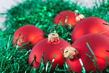 Red Christmas toys on green tinsel