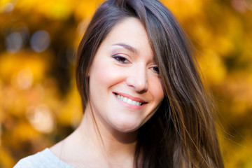 Portrait of beautiful young woman in autumn park