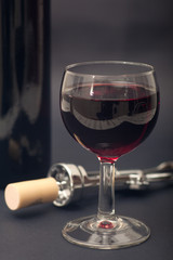 Glass, corkscrew and bottle of wine