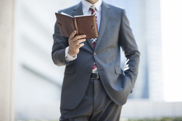 手帳を確認するビジネスマン