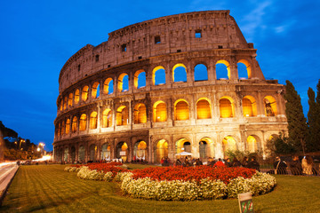 Beautiful view of Colosseum at sunset with flowerbed in foregrou