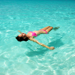 Woman in bikini lying on water