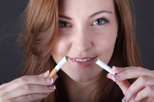 woman and stop smoking cigarette (focus on cigarette)