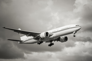 sepia toned unmarked passenger aircraft landing