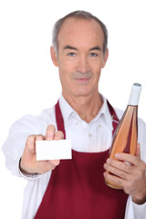 Waiter holding bottle of wine and blank business card