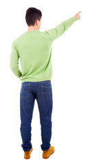 Young casual man pointing at something over white background