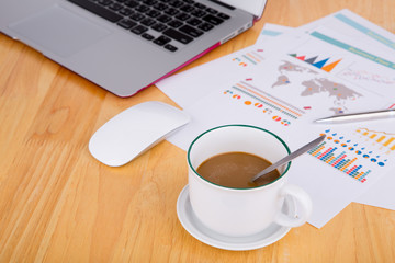 Financial chart on the table with laptop, coffee and pen