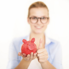 Junge Blondine mit Sparschwein