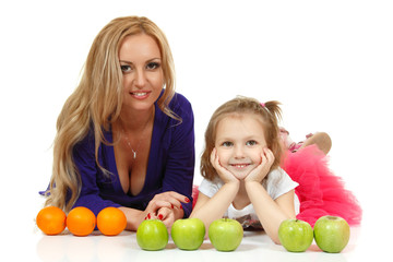 Fototapeta na wymiar Matka z córką liitle z jabłek i pomarańczy