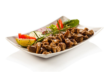 Grilled meat and vegetables on white background