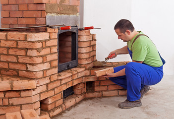 Worker building masonry heater