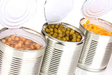 Open tin cans of corn, beans and peas isolated on white