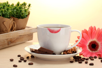 cup of coffee with lipstick mark and gerbera beans, cinnamon