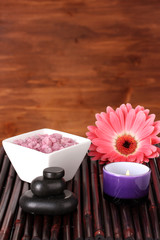 Composition of spa stones, bath salt, candle and gerbera