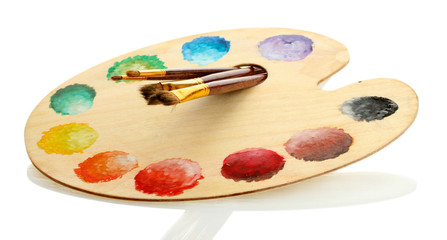 wooden art palette with paint and brushes isolated on white