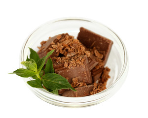 Pieces of chocolate and mint in the bowl isolated on white