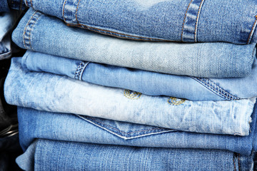 Fototapeta premium Many jeans stacked in a pile closeup