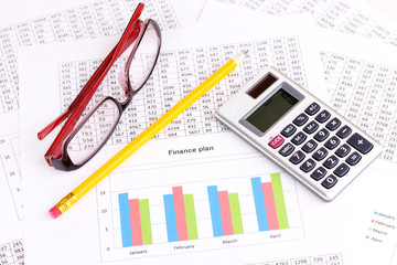 Documents, calculator and glasses close-up.