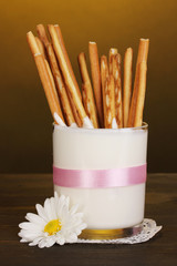 Tasty crispy sticks in glass with sour cream