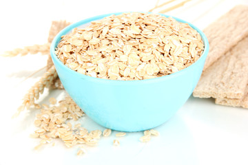 Blue bowl full of oat flakes with spikelets and oat biscuits