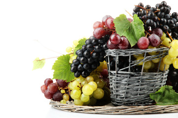 assortment of ripe sweet grapes in basket, isolated on white.