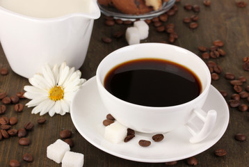 A cup of strong coffee and sweet cream on wooden table close-up