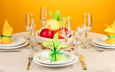 Table setting in green and yellow tones on color  background
