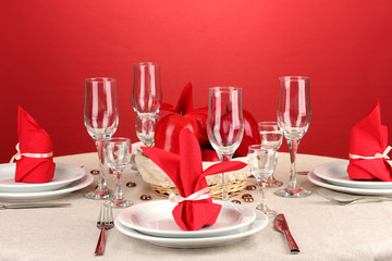 Table setting in red tones on color  background