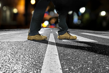 man crossing street at night - obrazy, fototapety, plakaty