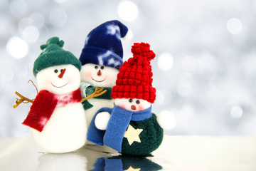 Family of snowmen with twinkling silver light background