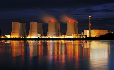 Nuclear power plant by night with reflection