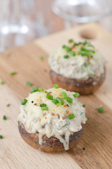 Stuffed mushrooms, baked with cheese and herbs on a wooden board