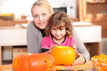 Mother and daughter decorating pumpkins