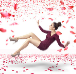 Attractive lady falling down over rose petals background