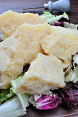 Pezzi di parmigiano su foglie di insalata