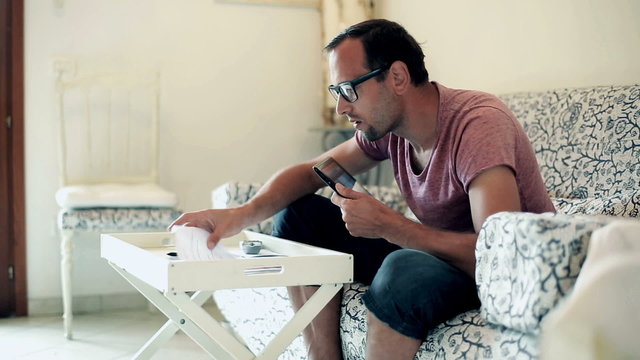 Stressed man doing his finances with tablet computer at home 
