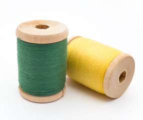 Two bright wooden spools of thread