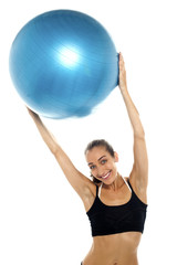 Fototapeta premium woman holding big blue pilates ball above her head