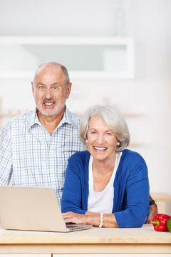 älteres ehepaar mit laptop in der küche