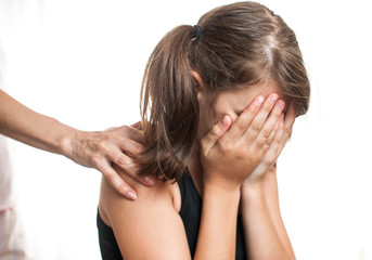 Depressed teenager sitting while hand coming from behind 