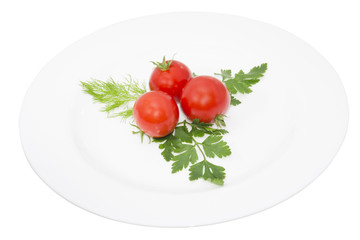 Tomato, greens in a plate, isolated