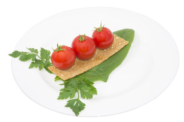 Tomato, snack and greens in a plate, isolated