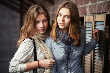 Young girls against a brick wall