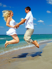 young happy couple having fun on sea beach