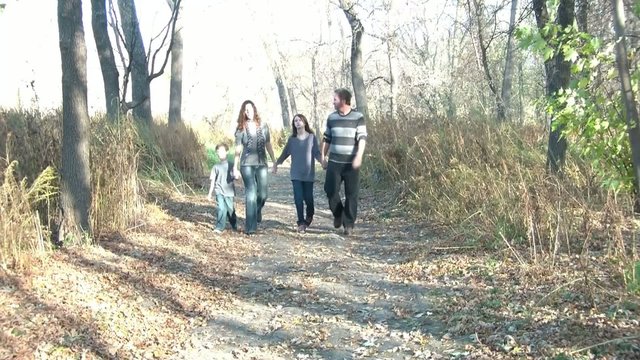 Family Walking through Woods in Fall